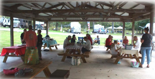 Group at picnic tables eating together.